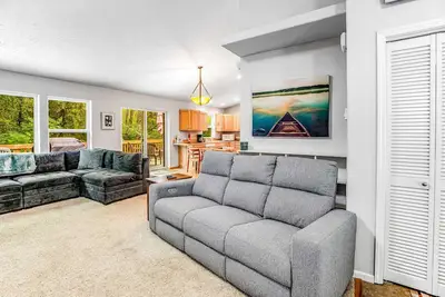 Image de Beautiful home with large deck gas grill nestled around the trees