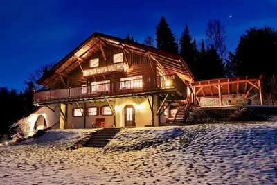 Image de Grand chalet en bois rond relaxant avec un spa.