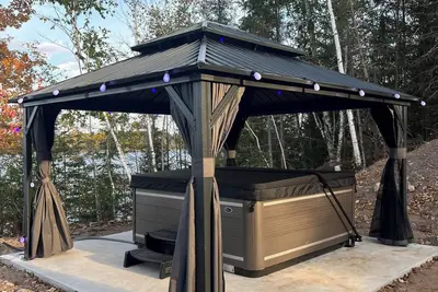 Image de Escape to Lakeview Paradise, a luxury 4-bed, 3-bath lakefront retreat in Tripoli, Wi. Each bedroom has a king bed, and the 2, 560 sq. ft. home features high-end finishes, cozy comforts, and stunning lake views from a private 24-ft deck or hot tub.