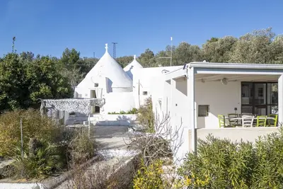 Image de Joli trullo blanc avec petite piscine et jardin