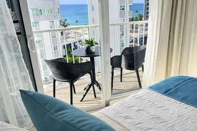 Refined apartment with partial ocean-view balcony, steps from Condado Beach.