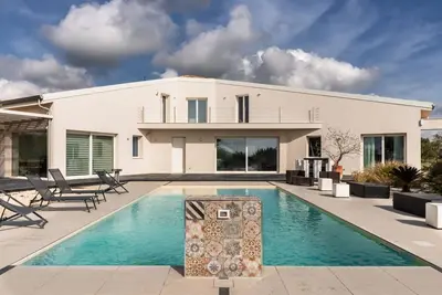 Image de Pizzuta Country House is an elegant and charming residence that elegantly interprets the most authentic soul of Sicily. Surrounded by over a hectare of centuries-old olive groves and enveloped by the scents of the Mediterranean scrub, the property offers