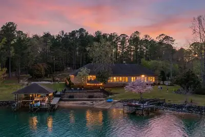 Image de Escape to this stunning 6 bed, 5 bath lakefront home, perfect for large groups & family getaways. With space to sleep up to 20 guests, this home features expansive indoor living areas & breathtaking lake views throughout.