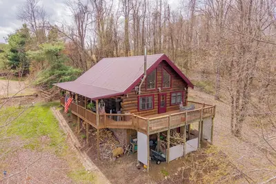 Image de Peaceful log cabin retreat with wraparound deck, open living space, full kitchen, cozy bedrooms & scenic wooded views.