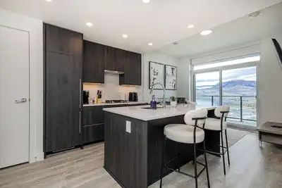 Image de Modern 1-bedroom condo on Water St in downtown Kelowna, steps to the beach and park. Lake views, plus pool, sauna, steam room, gym, yoga studio, golf simulator & wine room. Walk to dining, shops & trails—perfect for a relaxing stay.