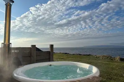 Image de At the edge of the sea, this stunning house has a wood fired hot tub.