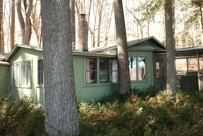 Image de This 1920's river cabin is full of vintage charm. Nestled in a grove of white pines on the banks of the scenic saint croix river, this three bedroom, one bath cabin offers a space designed for rest and simplicity.