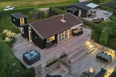 Image de Une maison en bois lumineuse avec un spa extérieur et une vue sur la mer