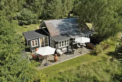 Image de Maison en bois avec un jardin sauvage près de la baie de Sejerø