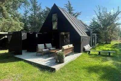 Image de Petite maison en bois confortable sur deux étages, située sur un terrain naturel