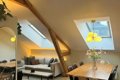Image de Appartement mansardé avec poutres apparentes et une hauteur sous plafond de 4 mètres