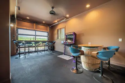 Image de Welcome to this spectacular home, which stands out for its soaring stone fireplace, a bright sunroom, and a unique indoor-outdoor entertainment lounge with a classic arcade game!