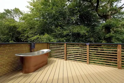 Image de Riverside lodge with spacious decking, Ninja Bbq, Wi-Fi, Netflix-ready Tv, Ev charging and an outdoor copper bath and shower for a wellness experience in nature. Up to three well-behaved dogs are welcome in selected lodges.