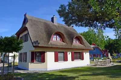 Image de Maison de vacances luxueuse au toit de chaume, à environ 500 m de la plage de sable, avec cheminée et sauna