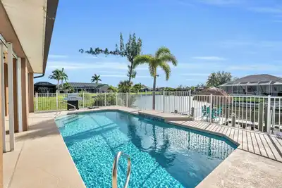Image de Belle maison au bord de l'eau avec piscine chauffée et grande véranda.