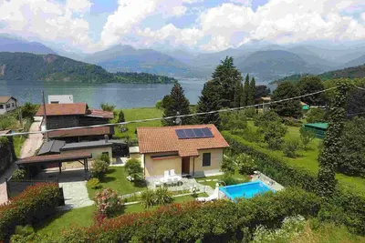 Image de Maison au bord du lac avec piscine chauffée à l'énergie solaire, vue sur le lac, jardin, cheminée (amarre pour bateau)