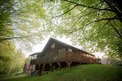 Image de La maison de cèdre est uniquement située dans la forêt entourée de terrasses et de porches.