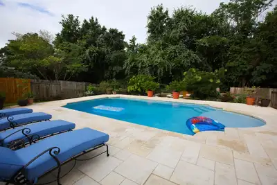 Image de Belle maison avec piscine personnalisée près de la zone de vie nocturne populaire.