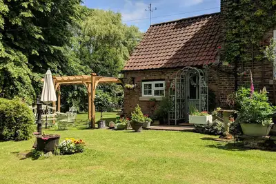 Image de Un charmant chalet au bord de la rivière dans de jolis jardins près de Langrick, Boston.