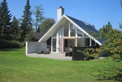 Image de Charmante maison avec terrasses en bois et incrustations de lumière fantastiques