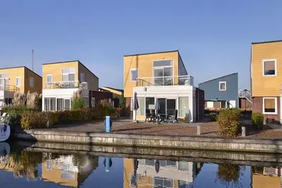 Image de Une maison insulaire avec terrasse fermée sur l’eau. La maison voisine Slaak 65 est aménagée à l’ide