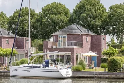 Image de Une maison luxueusement avec terrasse extérieure couverte et un l’aménagement beachstyle.