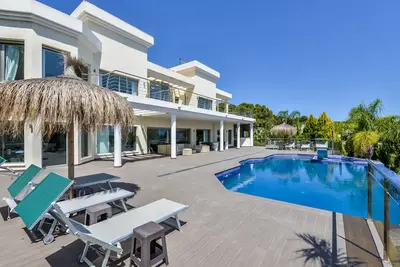 Image de Grande villa moderne avec piscine intérieure et extérieure, sauna et bar.