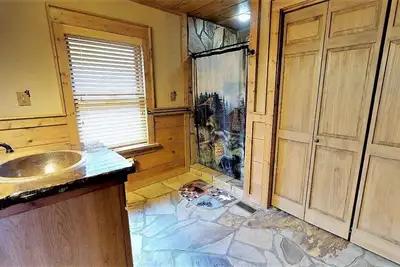 Image de Serenity On The Mountain offre des accents de pierre avec de grandes fenêtres personnalisées pour profiter de la vue. P