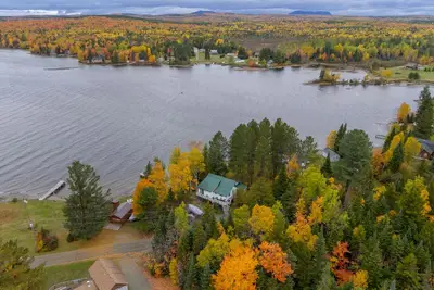 Image de Cabine au bord du lac avec rampe de bateau privée et accès au lac, véranda enveloppante, foyer