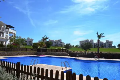 Appartement d'angle au rez-de-chaussée avec terrasse et piscine. Vues sur le terrain de golf et les collines