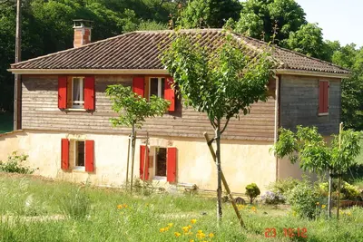 Image de Maison à la campagne, avec de grandes étendues de bois et de champs.