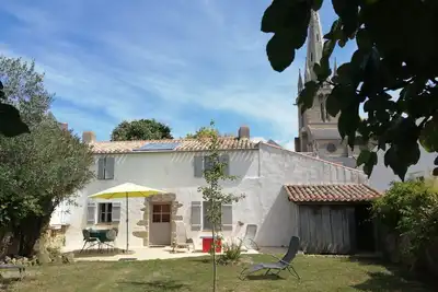 Image de une charmante petite maison au fond d'un jardin clôturé de murs en pierre