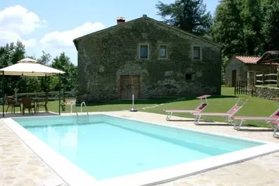 Image de Typique maison en pierre avec piscine privée et jardin, située dans une position vallonnée à quelque