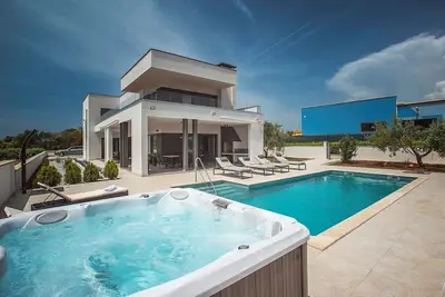 Image de Cette villa avec piscine est entourée par la nature et dispose d'un court de tennis.