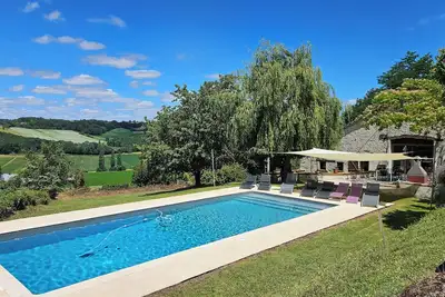 Image de Grange spacieuse, magnifiquement convertie avec poutres apparentes, piscine