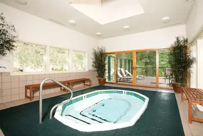 Image de Condo spacieux avec cuisine complète, accès au bain à remous, service de navette + local à ski