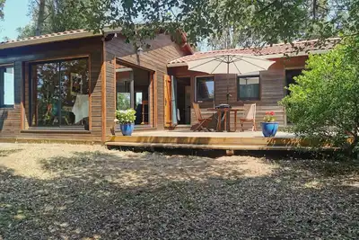 Image de Maison vue mer avec grande terrasse et terrain arboré.