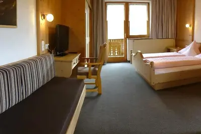 Image de Chambre triple \"Holzleiten\" avec coin salon - Pension Alpenhof - Pension de bien-être