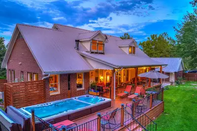 Image de Charmeur de pays avec porches avant et arrière invitants, spa de nage, terrasses, foyer
