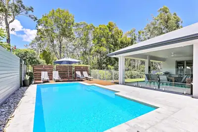 Image de Maison de style complexe privé avec chauffage de piscine solaire et toile de fond Bush