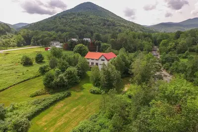 Image de Songbird Haven – Majestic Vt Timberframe, maison pour chiens le long de la rivière Blanche
