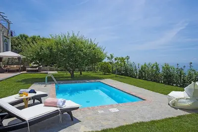 Image de Golden Villa: Une villa lumineuse et élégante de trois étages construite sur le sol en pente face à la mer.