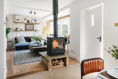Image de Cotswold Stone Cottage avec un intérieur élégant, des canapés et des lits confortables et un patio ensoleillé