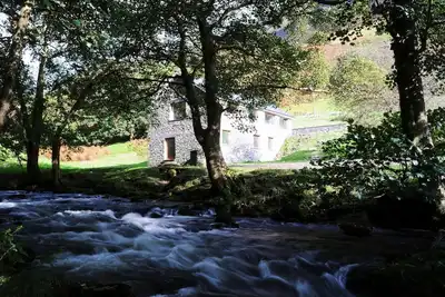 Image de Moulin à eau converti avec une belle rivière et des montagnes majestueuses à sa porte