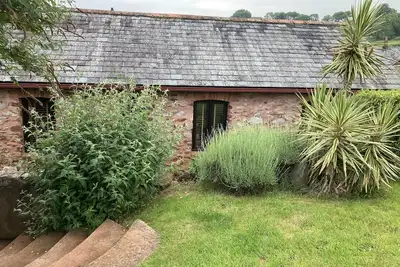 Image de Conversion de grange de caractère, décorée dans un style contemporain, avec jardin et parking.