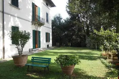 Image de villa historique avec piscine et grand jardin, située en position panoramique.