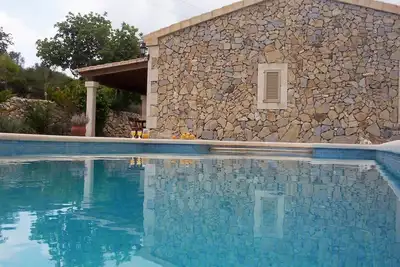 Image de Maison typique de Majorque avec terrasse et piscine avec beau coucher de soleil.