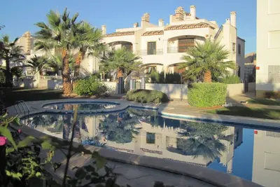 Image de condo agréable jardin à côté de la piscine.