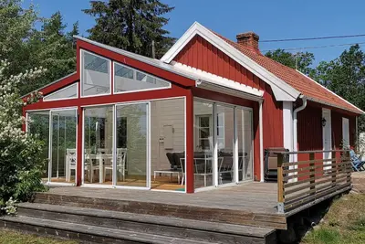 Image de Immeuble accueillant rouge Suède, juste à côté de la mer, entre forêt et prairie