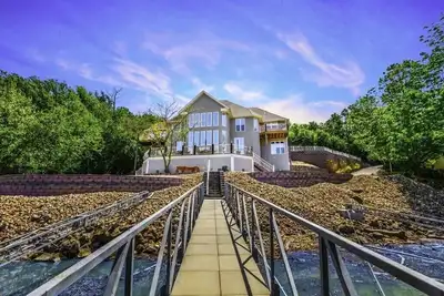 Image de spectaculaire plan d'étage ouvert de 6 chambres sur une eau calme et profonde récemment rénové